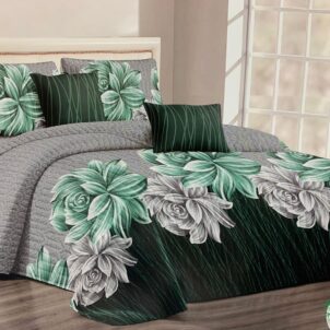 Elegant bedroom setup featuring a dark green and gray quilted bedspread adorned with large, detailed floral patterns in shades of green and white. The bedding set includes matching floral pillows and solid dark green accent pillows, creating a lush, botanical theme. The room is softly lit with a modern aesthetic, complemented by large windows allowing natural light to fill the space.