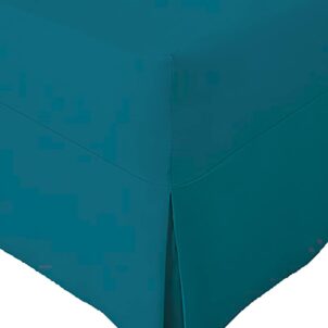 Close-up of a corner section of a turq bed skirt with a tailored design. Part of a combo set, the bed skirt features a neat pleat at the corner, draping smoothly to the floor. The fabric appears soft and pastel in color.