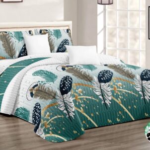 A bedroom features a neatly made bed with a quilt and pillow set adorned with a colorful leaf and feather pattern. The room is bright with large windows, wooden flooring, and a cozy ambiance.