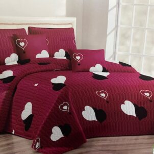 Deep red quilt adorned with fun, bold heart patterns in white and black, adding a playful and lively vibe to the space.