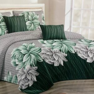 Bold and bright green and white flower-patterned quilt bedding set with a splash of grey, adding a touch of elegance to a stylish bedroom.