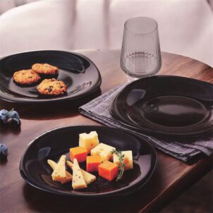 Set of glossy black cake plates stacked neatly on a table.