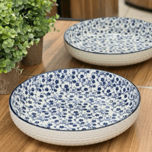 Large salad, fruit, or soup bowl set against a white background, featuring a decorative pattern of blue flowers for a classic and elegant look.