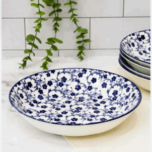 Soup bowl set against a white background, featuring a decorative pattern of blue flowers for a classic and elegant look.