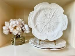 White serving platter designed in the shape of a cabbage leaf, adding a touch of organic charm and texture to the presentation.