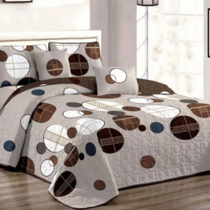 A grey quilt featuring circular patterns in brown, white, and blue accents.