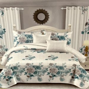 A white quilt featuring grey and blue floral patterns.