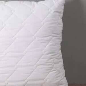 Pillow with a quilted pinsonic pattern on the cover.