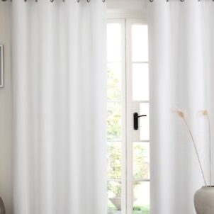 Two white blackout curtains on a window, blocking sunlight and creating a clean, fresh look for any room.